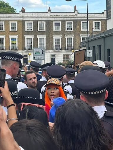 Person with orange hair surrounded by police