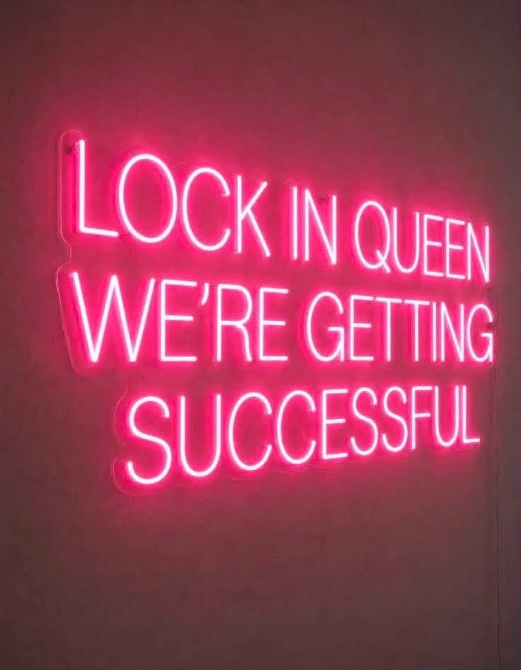 Pink neon sign reading motivational success message