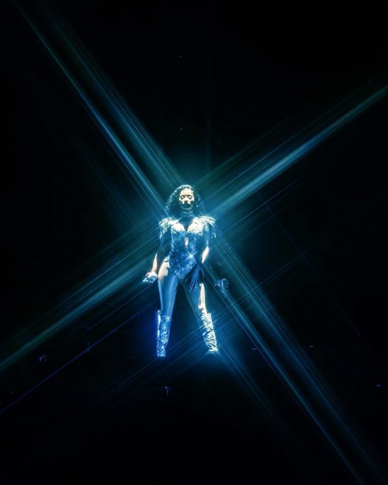 Performer suspended in blue laser X light