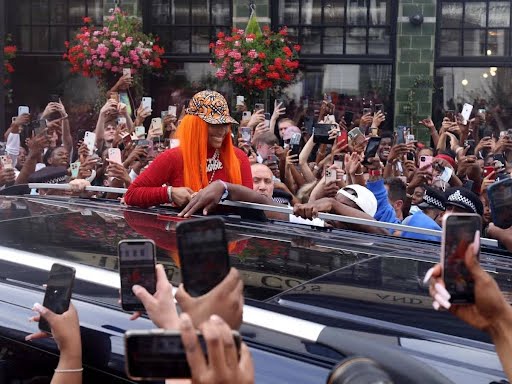 Person with orange hair leaning from car sunroof